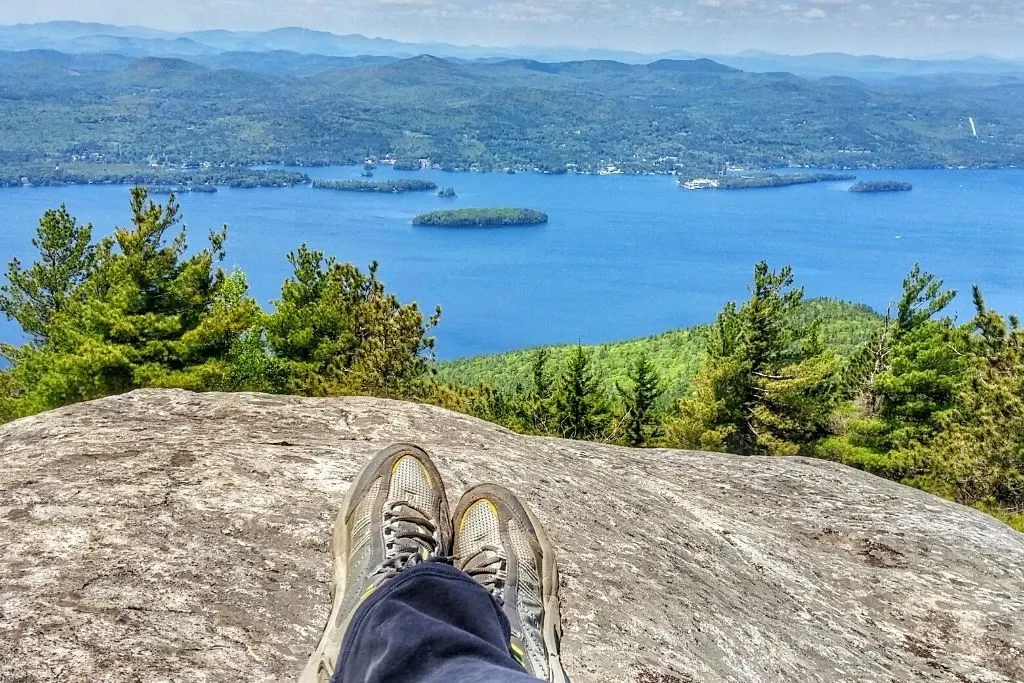 One of the best things to do in Lake George NY is climb to the top of Buck Mountain and get this aerial view of Lake George with the green hills in the background.