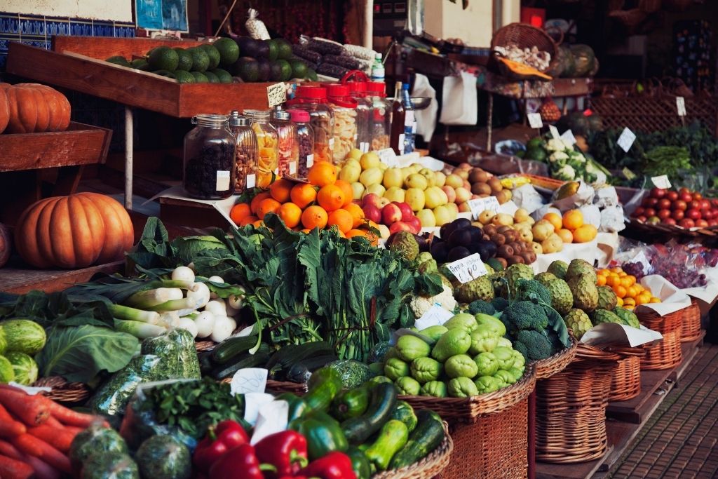 Colorful fruit stacked n shelves alongside other produce in the outdoor markets which are super fun to explore and are one of the fun things to do in Woodstock NY.