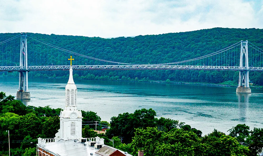 View from the Walkway Over the Hudson with the green banks of the river and a white tower is one of the best things to do in Poughkeepsie NY