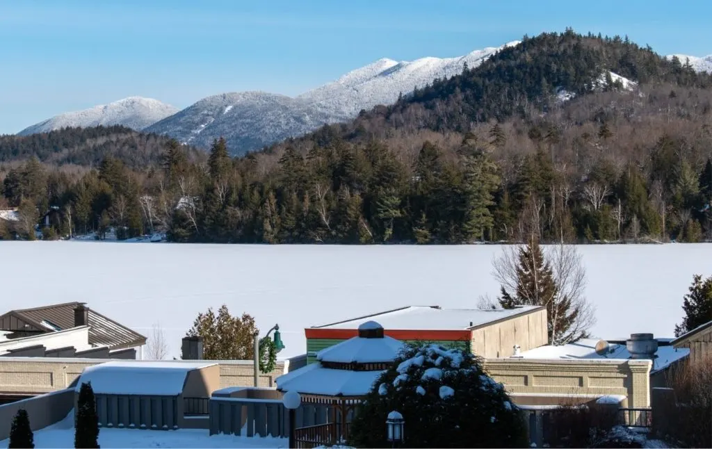 Lake Placid in winter with snow on the buildings and Mirror Lake frozen. 