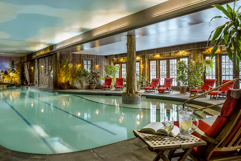 Indoor pool with red chairs around it at the Mirror Lake In in Lake Placid. One of the areas with the best skiing in New York. 