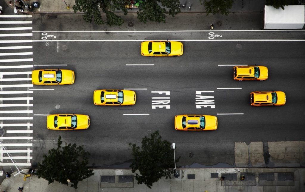 Aerial view of yellow cabs driving down the street in NYC.