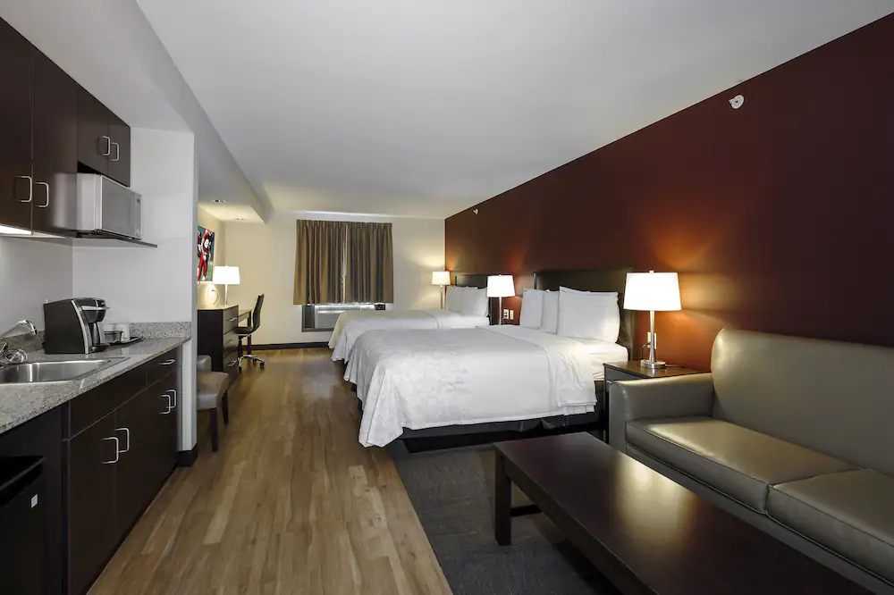 Modern, well-appointed, family-suite with two queen beds inside the Red Roof Inn PLUS+ & Suites Malone.
