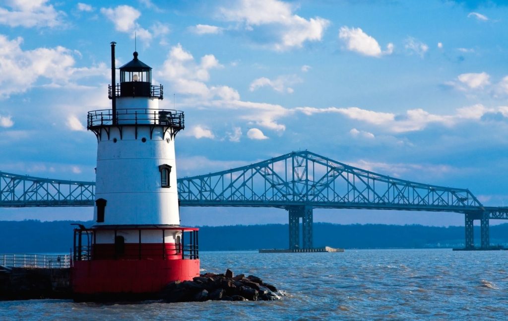 Tarrytown Lighthouse with the Tappan Zee Bridge in the background on the Hudson River is one of the iconic sights in Sleepy Hollow NY