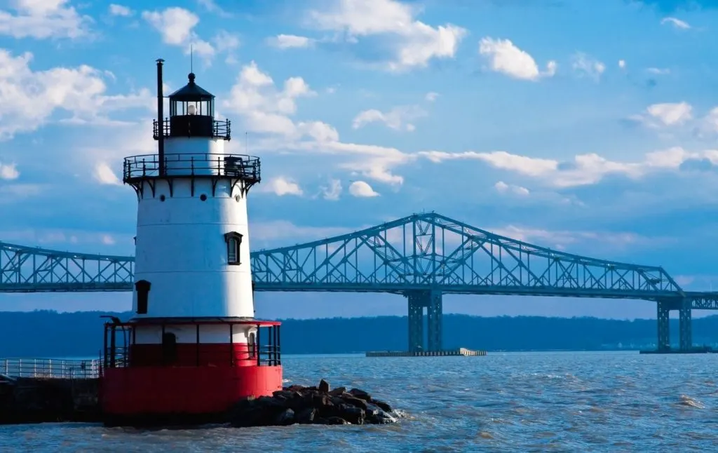 Tarrytown Lighthouse with the Tappan Zee Bridge in the background on the Hudson River is one of the iconic sights in Sleepy Hollow NY