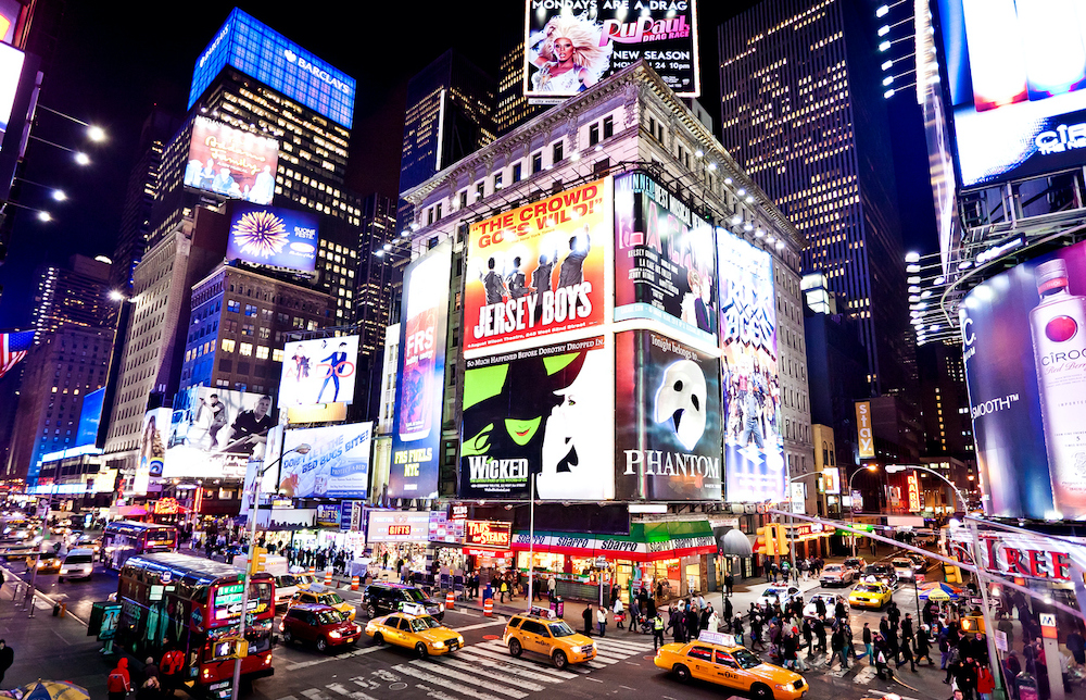 Times Square lit up in the night with its billboard and the iconic yellow cabs. Times Square is one of the best things to do in NYC for your birthday.