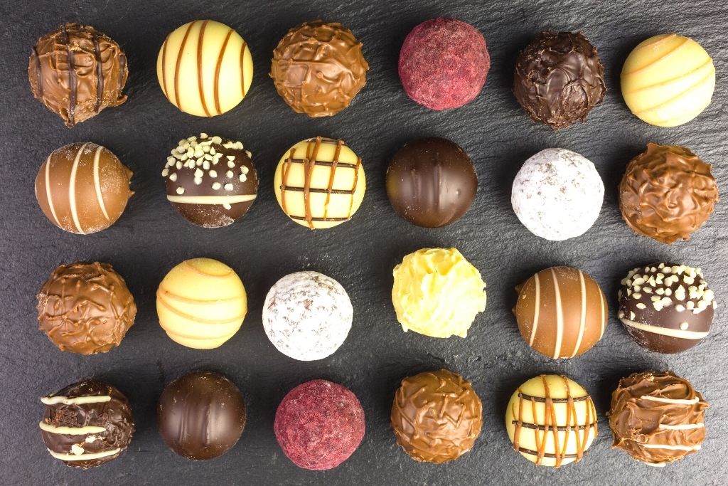 Homemade chocolate truffles on a granite counter. 