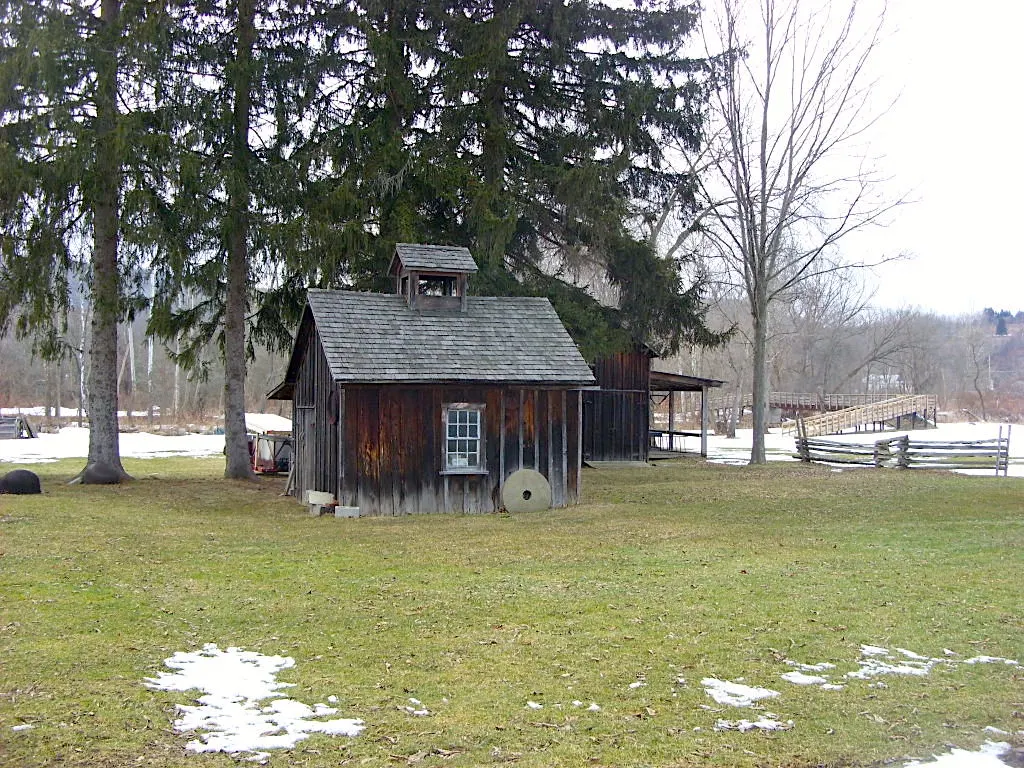 Historic wooden buildings with snow on the ground at the Bement-Billings Farmstead.