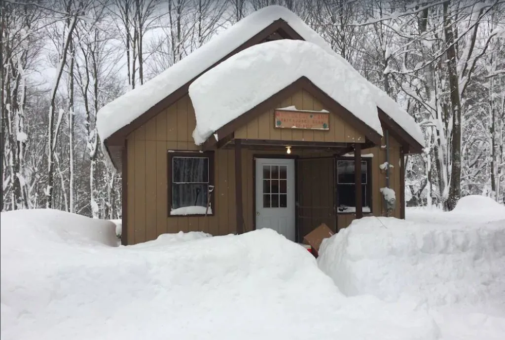 Cozy cabin covered in snow in the Finger Lakes of New York. 