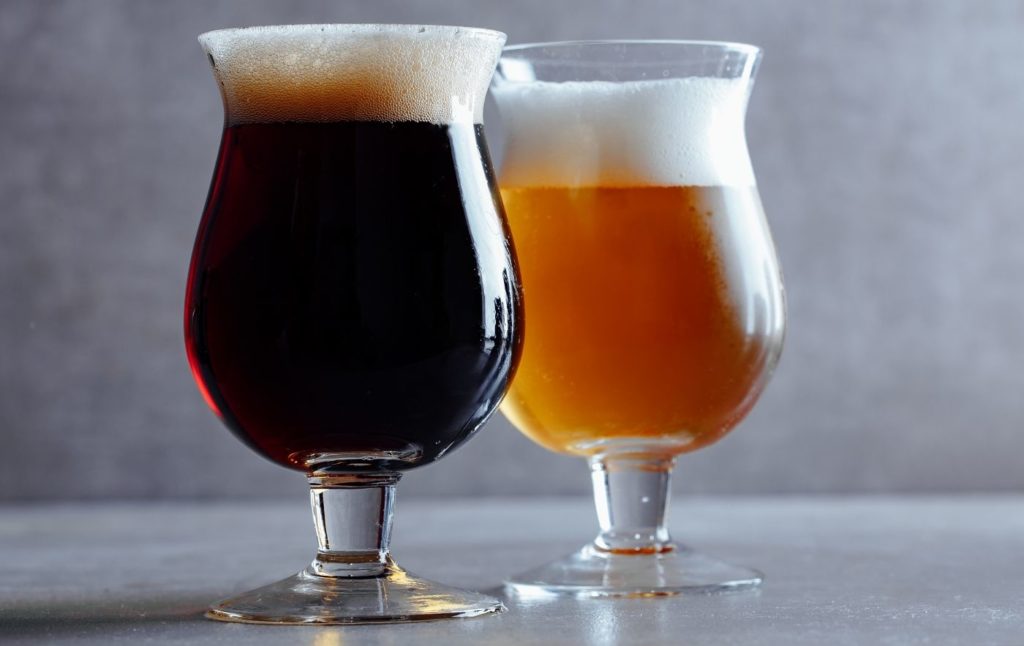 View of two beer glasses. One with light beer and one with dark beer.