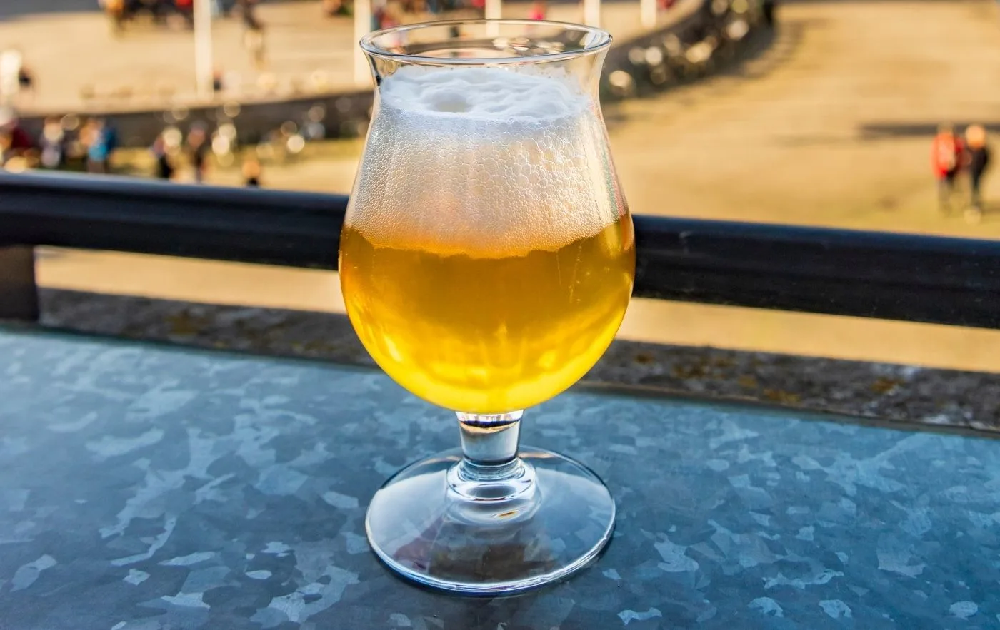 Light Belgian ale in a glass on a table.