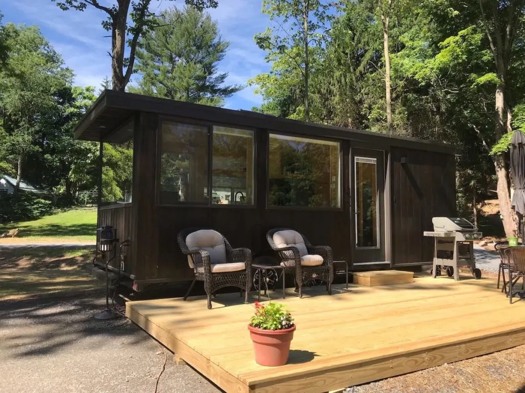Mocha colored tiny house with a deck in the South Cairo, NY. 