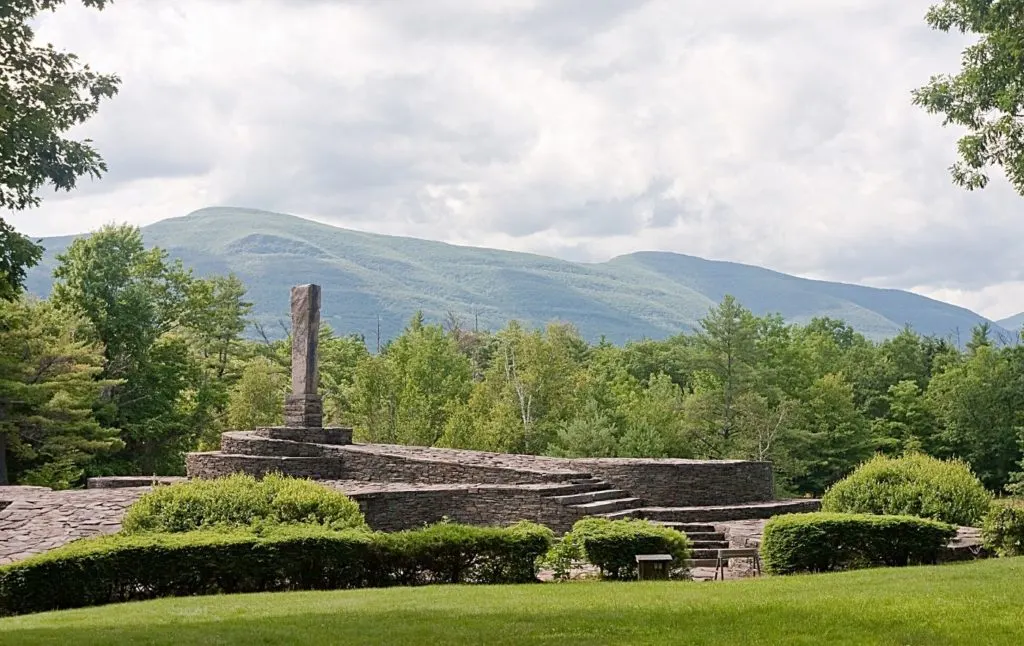 View of the Opus 40 sculpture park with stunning green mountains in the background. beckons you to indulge in one of the fun things to do in Woodstock NY.