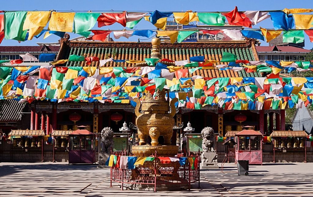 Tibetan Temple with vibrant prayer flags out front.