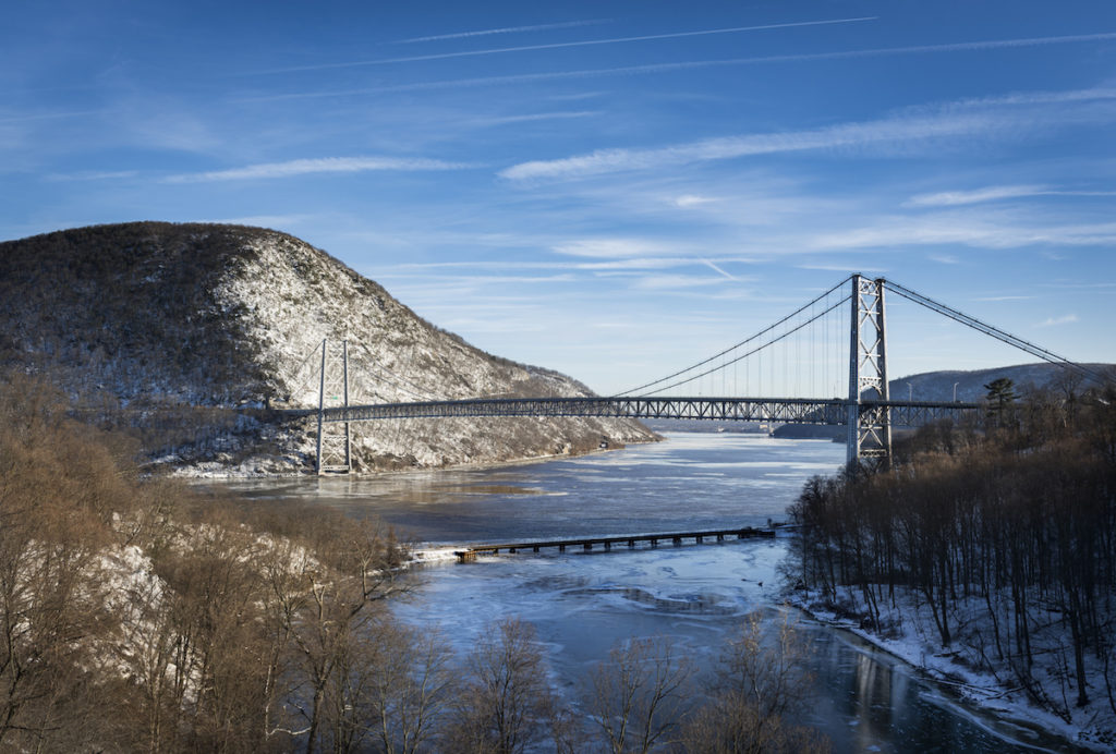 Bear Mountain Bridge from Anthony's Nose to Bear Mountain across the Hudson with the surrounding mountains covered in snow. 