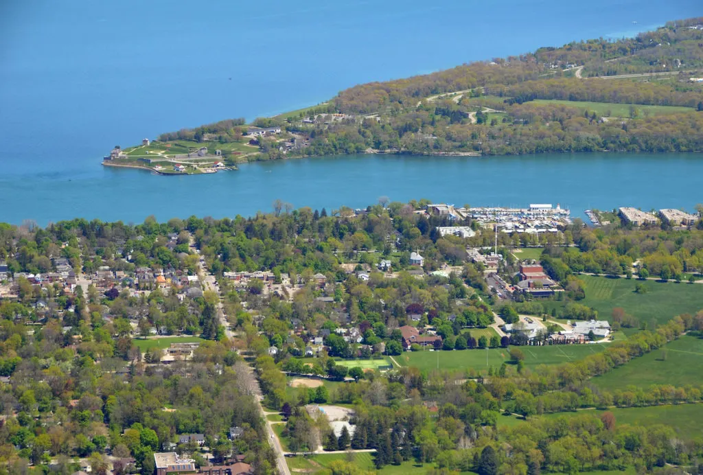 Aerial view of Lake Ontario  with the green swats of land with sporadic buildings is just one of the views that you can catch on your hikes in the Finger Lakes of New York. 