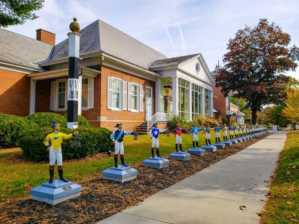 Lawn jockeys in colorful shirts and extended hands out front of the National Museum of Racing Hall of Fame which is one of the cool things to do in Saratoga Springs