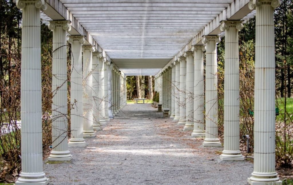 A white column lined, open walkway through Yaddo Gardens. One of the best things to do in Saratoga Springs NY. 