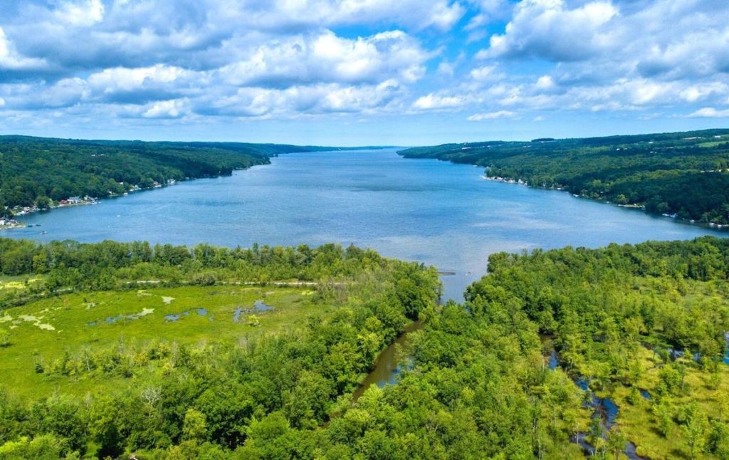Aerial view of the green shores and blue waters of Owasco Lake, one of the best lakes in New York State.
