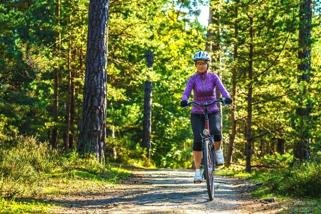 Female biker on a path and experiencing one of the best things to do in Lake George NY. 