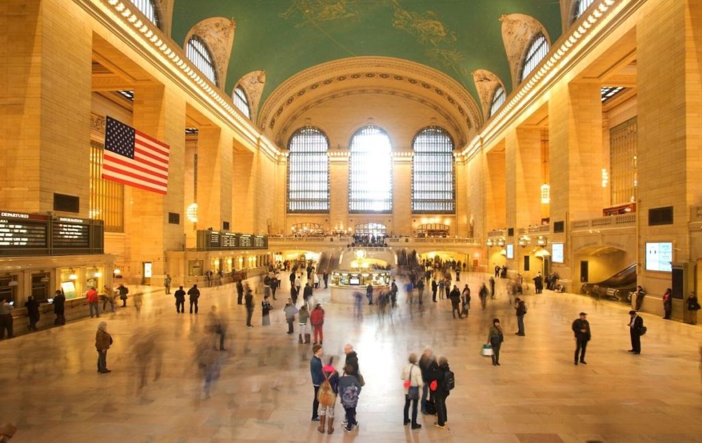 Interior of Grand Central Terminal with people walking everywhere which is above one of the best restaurants in NYC.