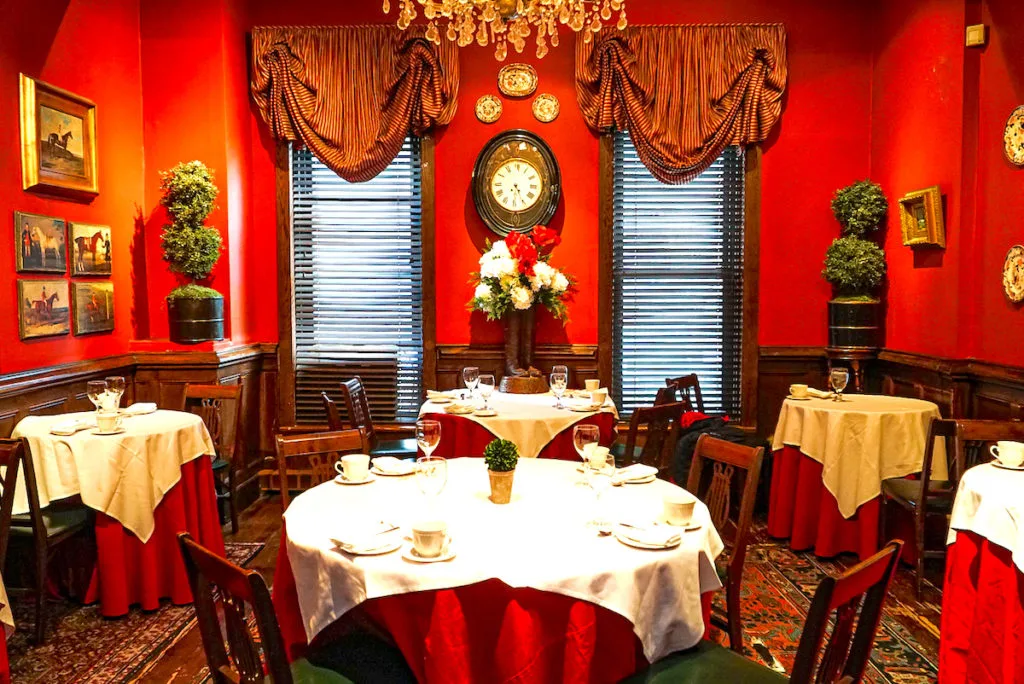 Vibrant red interior of King's Carriage House, one of the unusual restaurants in NYC. 