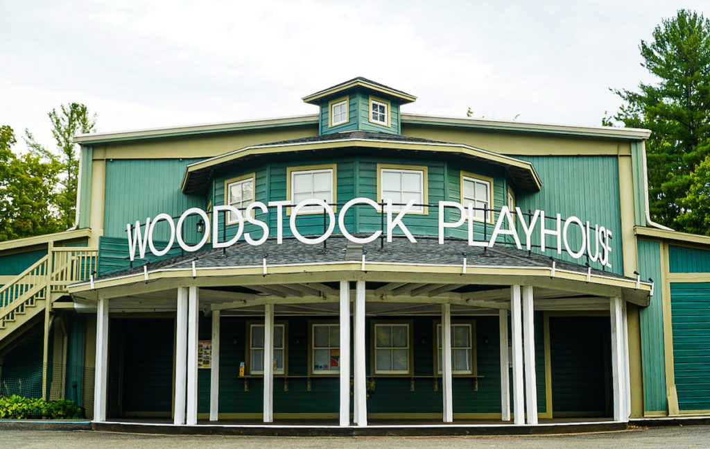 The exterior of the green wooden building of the Woodstock Playhouse which houses one of the coolest things to do in Woodstock NY.