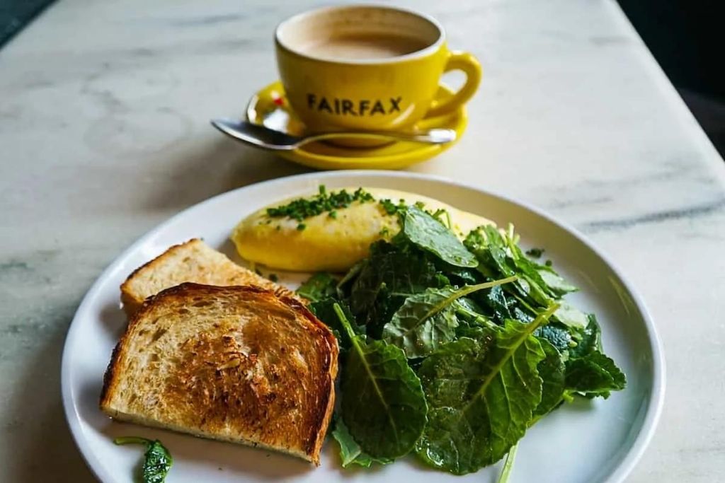 Omelet with side salad and giant yellow mug of coffee at Fairfax, fun brunch NYC. 