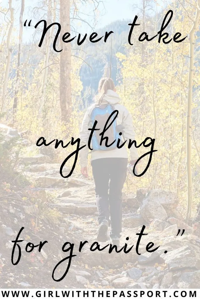 A lady walking with a blue backpack in a forest with a hiking pun written on it.