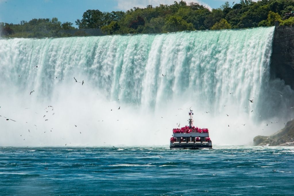 A cruise ship with tourists taking them away from Niagara Falls, is one of the best things to do in Niagara Falls./ 