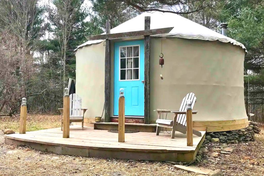 Yurt with a bright blue door at Mariaville Goat Farm, one fo the best places for glamping in New York. 