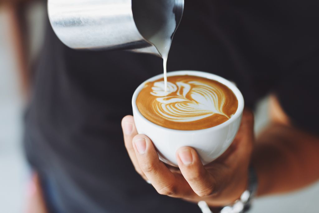 Barista making a latte at one of the top Brooklyn coffee shops. 