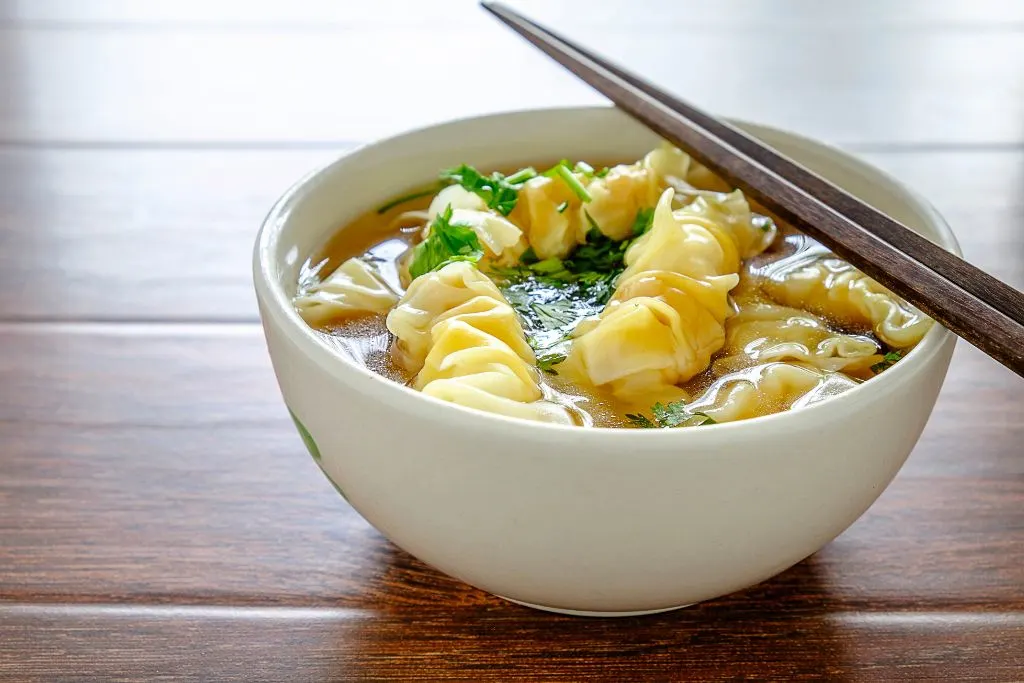 Wonton soup in a bowl from Wu's Wonton King, one fo the places you must eat in NYC. 