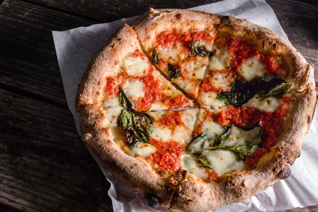 Wood-fired pizza with veggies on top from one of the places you must eat in NYC. 