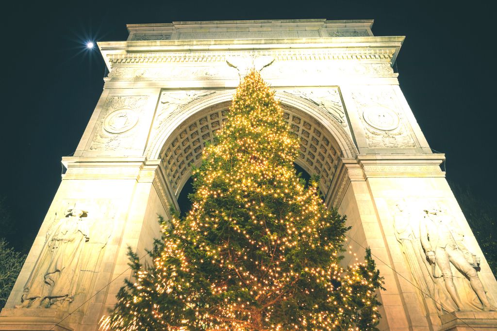Giant Christmas tree in front of the arch in Washington Square Park, one of the best places to see Christmas lights in NYC. 