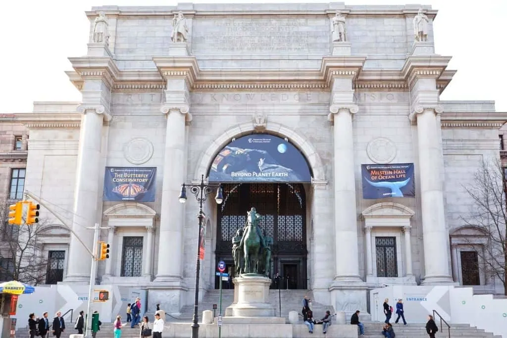 Stone exterior of the Museum of Natural History on the Upper West Side. with a horse statue out front.