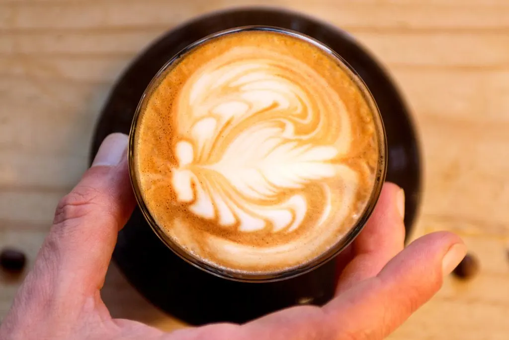 A person holding a flat white  at one of the best coffee shops in New York City. 