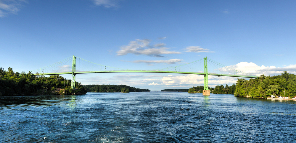 View of the green, thousand island bridge that connects Ontario with New York and is one of the best things to do in Alexandria Bay NY. 