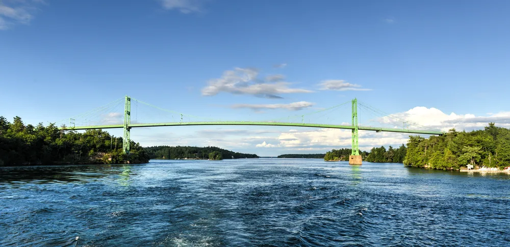 View of the green, thousand island bridge that connects Ontario with New York and is one of the best things to do in Alexandria Bay NY. 