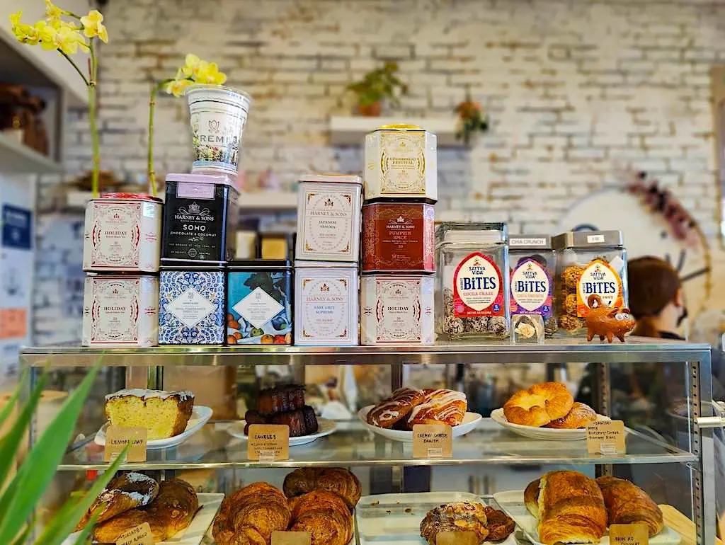 Teas and pastries on the counter in front of white-washed brick walls at Remi Flower and Coffee. 