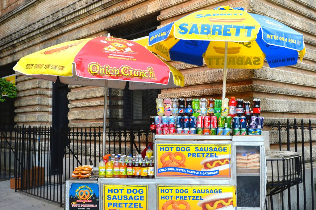 Hot dog vendor on a street corner in New York City.  