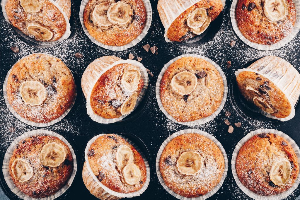 Vegan banana chocolate chip muffins dusted in powdered sugar from one of the best vegan bakeries in New York City. 