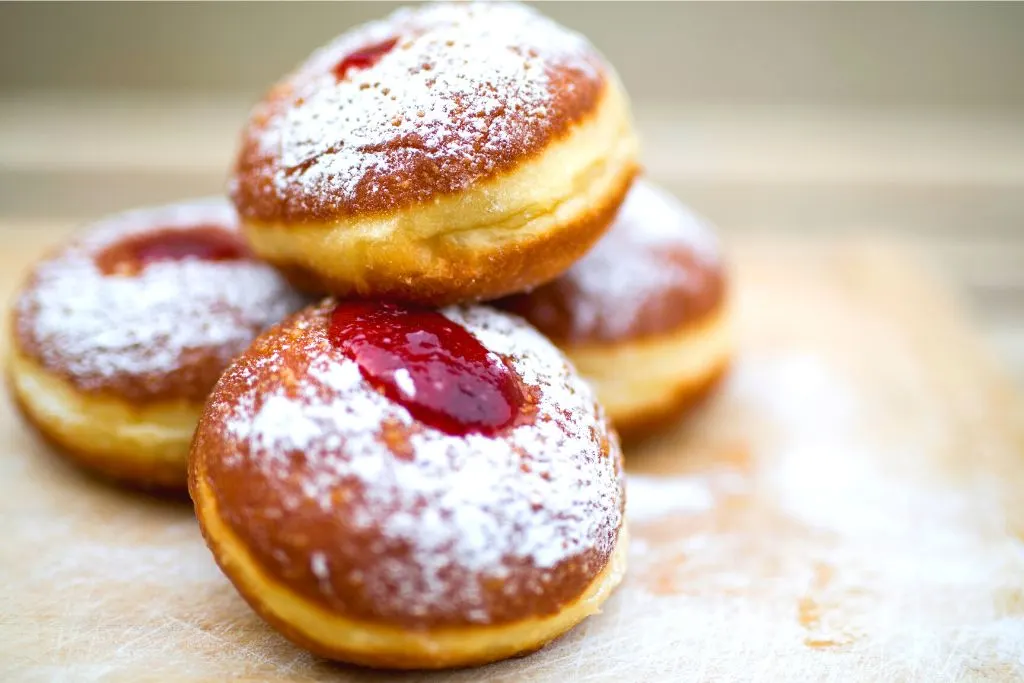 Homemade jelly doughnuts with powdered sugar on top. 
