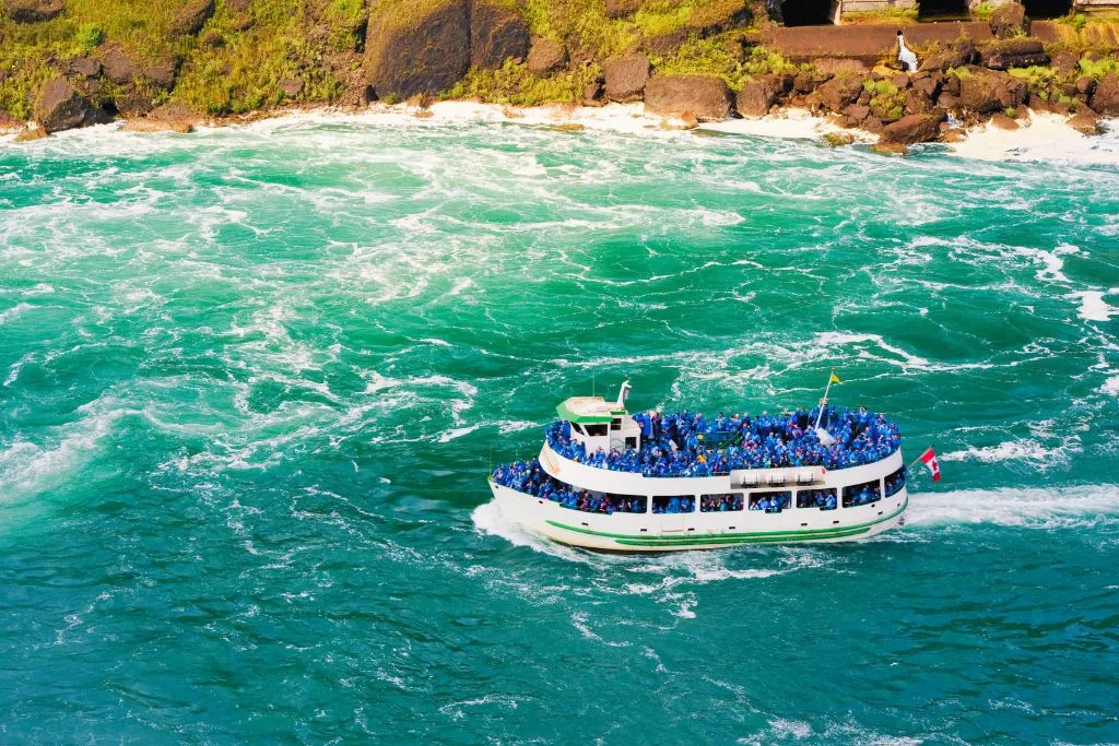 Aerial view of the Maid of the Mist boat tour in the water of Niagara Falls. 