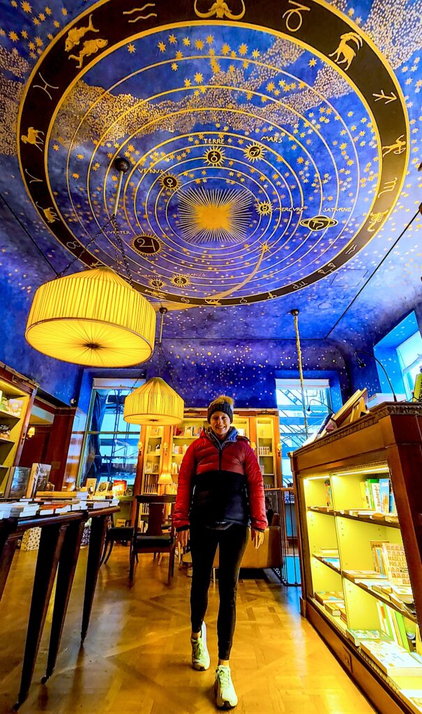Kelly standing inside of Albertine with the beautiful star-studded ceiling in the background.