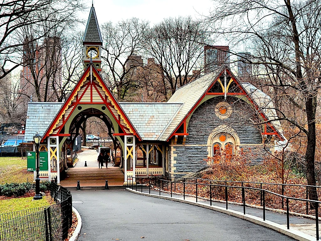 A view of the charming visitor's center in Central Park. Stop by if you want to visit new York in Janaruy. It has a vintage vibe with a steepled roof and gray panels.