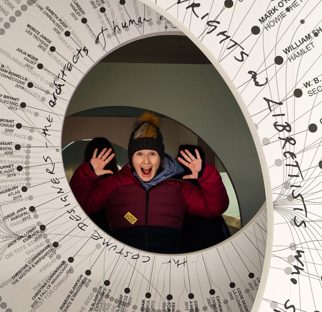 View of me in winter clothes inside the Cooper Hewitt Museum of Design.