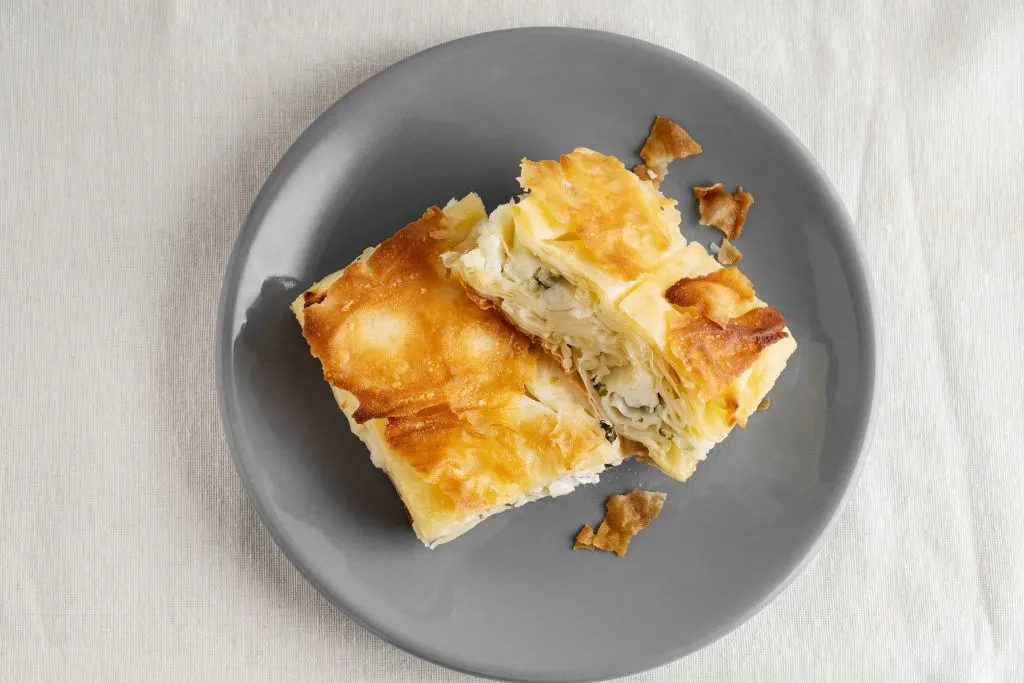 Two pieces of flaky Borek with cheese served on a gray plate from a place that has the best brunch in NYC. 