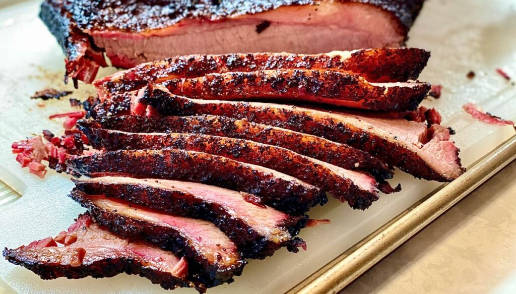 Pieces of freshly smoked, sliced brisket on a wooden platter from one of the best breweries in Lake Placid.