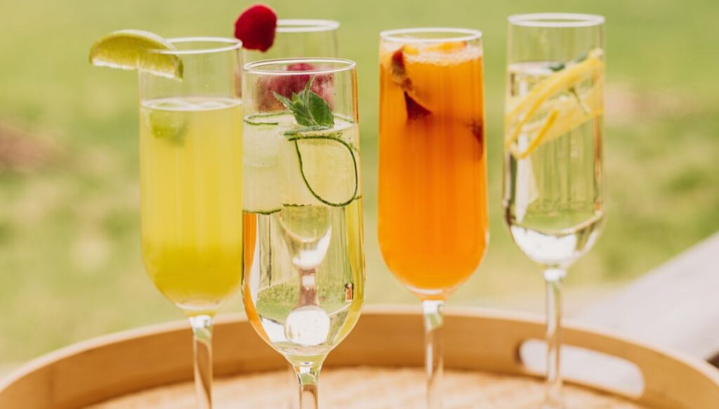 A selection of five different mimosas sitting on a try during the best drag brunch NYC has to offer. 